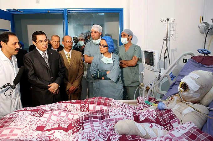 Tunisian President Zine El Abidine Ben Ali visits Mohamed Bouazizi, right, the protester who set himself alight during a demonstration against unemployment, at a hospital in Ben Arous near Tunis on December 28, 2010. [Tunisian Presidency Handout/Reuters]